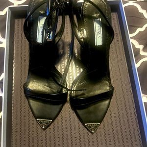 Black Prada sandals with logo on toe,strap and skinny heel. Worn for a hour,